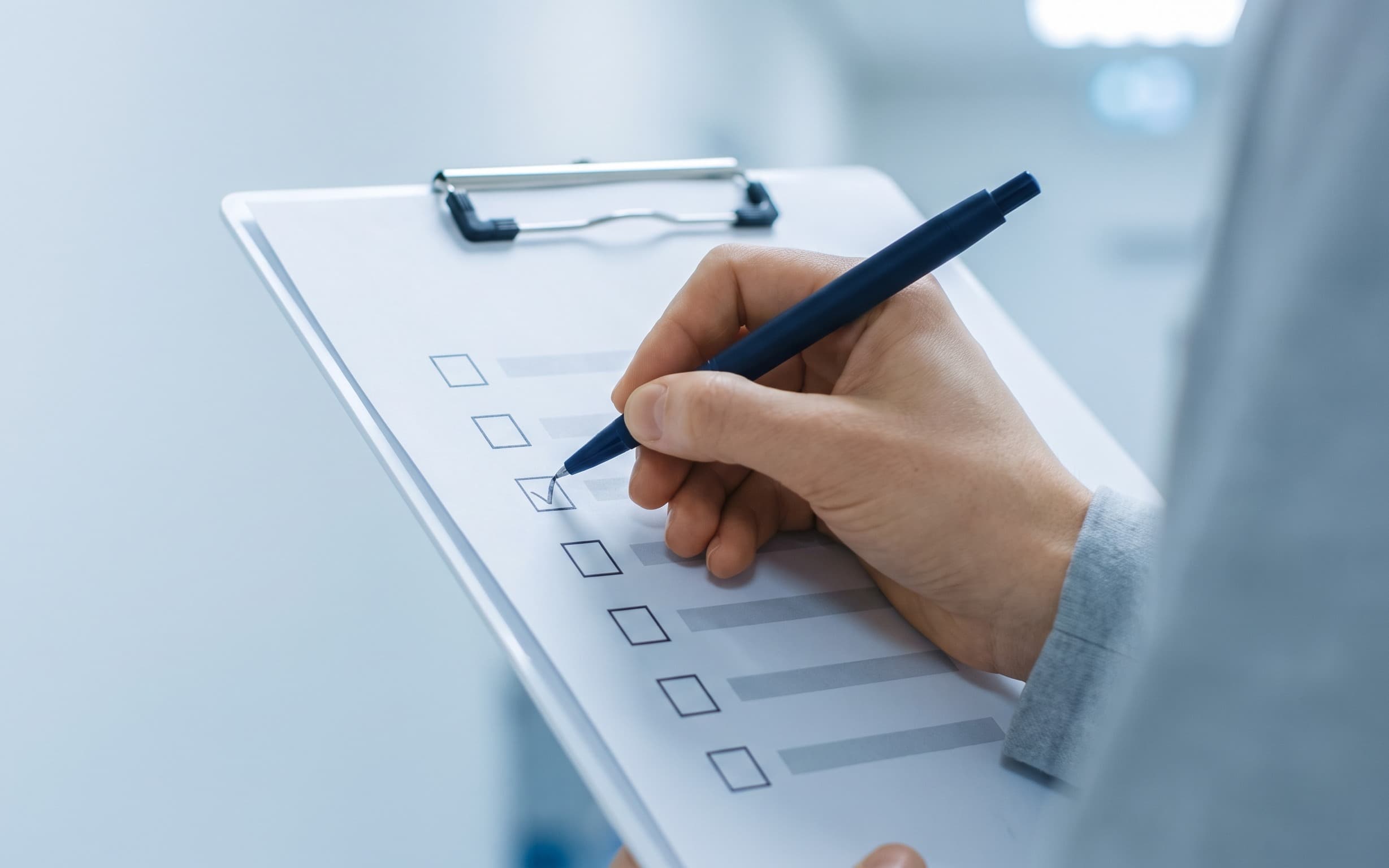 Hand checking a box on a clinical screening checklist